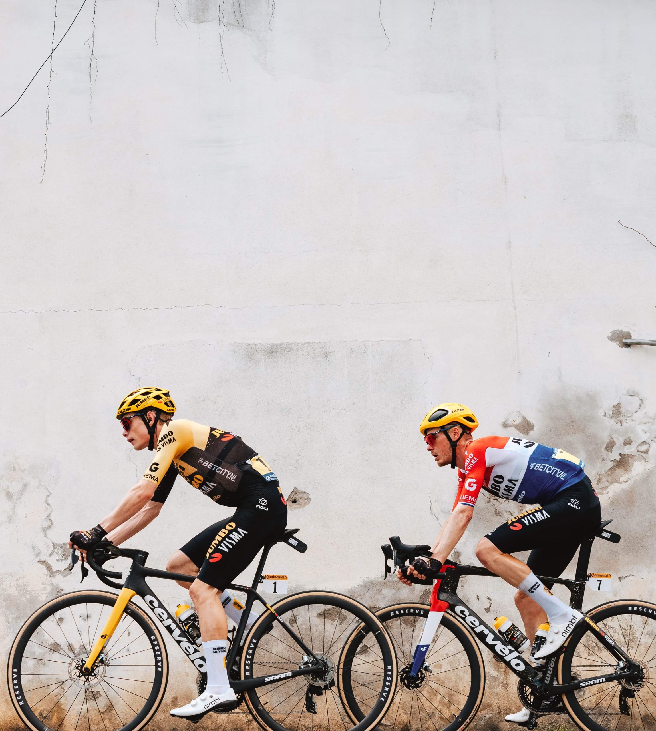 Cyclists in front of a wall